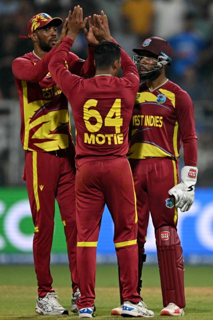 West Indies' Gudakesh Motie celebrates with teammates after taking the wicket of England's captain Harry Brook during the 2026 ICC Men's T20 Cricket World Cup group stage match between England and West Indies at the Wankhede Stadium in Mumbai on February 11, 2026. (Photo by Indranil MUKHERJEE / AFP)