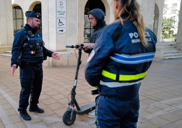 Local police officers checks the user of an electric scooter in Montpellier, southern France on February 11, 2026. The city of Montpellier issued a decree on November 2025 banning the use of electric scooters and similar vehicles in the Place de la Comédie, the Antigone district, and the main pedestrian streets of the historic center. (Photo by Sylvain THOMAS / AFP)