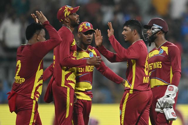 West Indies' Gudakesh Motie celebrates with teammates after taking the wicket of England's captain Harry Brook during the 2026 ICC Men's T20 Cricket World Cup group stage match between England and West Indies at the Wankhede Stadium in Mumbai on February 11, 2026. (Photo by Indranil MUKHERJEE / AFP)