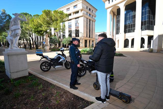 Local police officers check the user of an electric scooter in Montpellier, southern France on February 11, 2026. The city of Montpellier issued a decree on November 2025 banning the use of electric scooters and similar vehicles in the Place de la Comédie, the Antigone district, and the main pedestrian streets of the historic center. (Photo by Sylvain THOMAS / AFP)