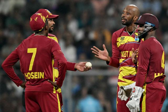 West Indies' Roston Chase (2R) talks to teammates during the 2026 ICC Men's T20 Cricket World Cup group stage match between England and West Indies at the Wankhede Stadium in Mumbai on February 11, 2026. (Photo by Indranil MUKHERJEE / AFP)