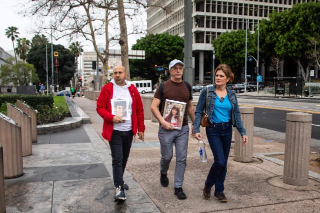 Parents from the United Kingdom George Nicolaou (L) Mariano Janin (C), and Ellen Roome Cheltenham (R) arrive holding photos of their children who took their own lives outside the Los Angeles County Superior Court in Los Angeles, on February 11, 2026. Arguments began February 9 in a landmark US trial that could establish a legal precedent on whether social media companies deliberately designed their platforms to lead to addiction in children. The case in Los Angeles Superior Court is being seen as a bellwether proceeding because its outcome could set the tone for a tidal wave of similar litigation across the United States. (Photo by Apu GOMES / AFP)