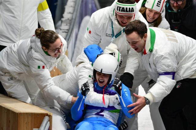 Italy's Andrea Voetter and Marion Oberhofer celebrate winning the gold medal in the luge women's doubles at Cortina Sliding Centre during the Milano Cortina 2026 Winter Olympic Games in Cortina d'Ampezzo on February 11, 2026. (Photo by Stefano RELLANDINI / AFP)