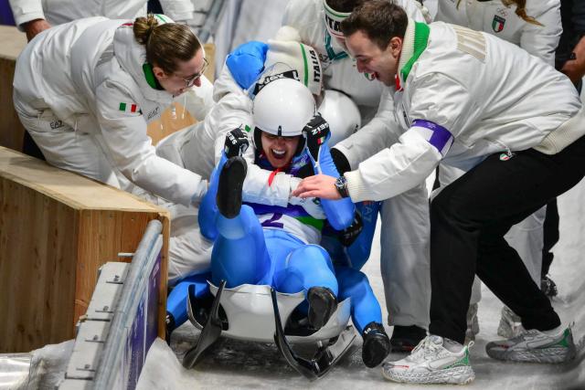Italy's Andrea Voetter and Marion Oberhofer celebrate winning the gold medal in the luge women's doubles at Cortina Sliding Centre during the Milano Cortina 2026 Winter Olympic Games in Cortina d'Ampezzo on February 11, 2026. (Photo by Stefano RELLANDINI / AFP)