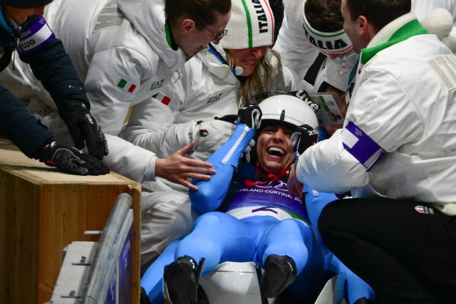 Italy's Andrea Voetter and Marion Oberhofer celebrate winning the gold medal in the luge women's doubles at Cortina Sliding Centre during the Milano Cortina 2026 Winter Olympic Games in Cortina d'Ampezzo on February 11, 2026. (Photo by Stefano RELLANDINI / AFP)