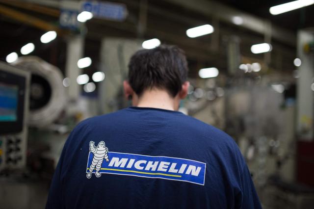 (FILES) This picture taken on shows an employee of French tyre maker "Michelin" wearing a sweater with the brand's logo on April 22, 2016 at the Michelin truck tyres factory of La roche-sur-Yon, western France. Tyre manufacturer Michelin saw its net profit fall by 12% to Ђ1.7 billion in 2025, hit by lower sales volumes, higher customs duties imposed by the United States and the stronger euro. (Photo by JEAN-SEBASTIEN EVRARD / AFP)
