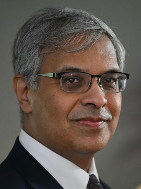 US National Institutes of Health (NIH) Director Jayanta (Jay) Bhattacharya looks on as US First Lady Melania Trump visits the Children's Inn at National Institutes of Health (NIH) in Bethesda, Maryland, on February 11, 2026. (Photo by ANDREW CABALLERO-REYNOLDS / AFP)
