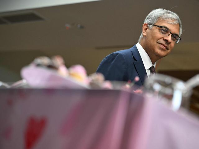 US National Institutes of Health (NIH) Director Jayanta (Jay) Bhattacharya looks on as US First Lady Melania Trump visits the Children's Inn at National Institutes of Health (NIH) in Bethesda, Maryland, on February 11, 2026. (Photo by ANDREW CABALLERO-REYNOLDS / AFP)