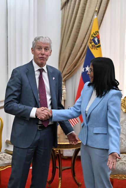 US Secretary of Energy Chris Wright (L) shakes hands with Venezuela's acting president Delcy Rodriguez before a meeting at the Miraflores Presidential Palace in Caracas on February 11, 2026. US Energy Secretary Chris Wright arrived in Venezuela on February 11 for talks with acting president Delcy Rodriguez and oil industry executives on harnessing the country's vast crude reserves. (Photo by Juan BARRETO / AFP)
