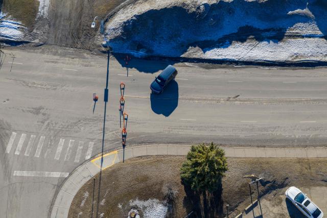 Law enforcement vehicles blocking the street are seen at the site of the middle school and high school building where a shooting took place, leaving at least nine people dead in the small town of Tumbler Ridge, British Columbia, on February 11, 2026. (Photo by Eagle Vision Agency / AFP)