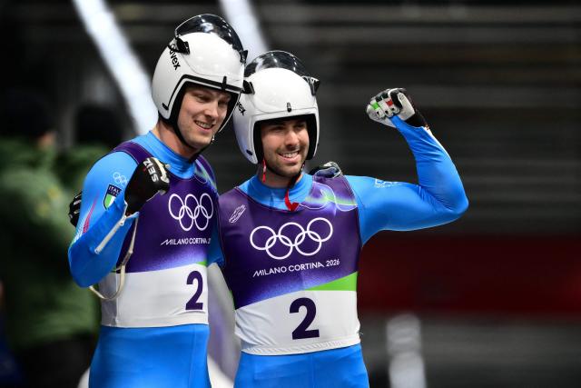 Italy's Ivan Nagler and Fabian Malleier react in the finish area of the luge men's doubles run 2 at Cortina Sliding Centre during the Milano Cortina 2026 Winter Olympic Games in Cortina d'Ampezzo on February 11, 2026. (Photo by Stefano RELLANDINI / AFP)