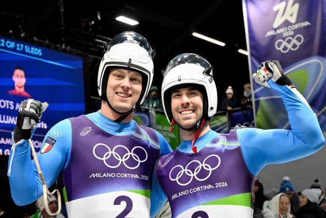 Italy's Ivan Nagler and Italy's Fabian Malleier react in the finish area of the luge men's doubles run 2 at Cortina Sliding Centre during the Milano Cortina 2026 Winter Olympic Games in Cortina d'Ampezzo on February 11, 2026. (Photo by Tiziana FABI / AFP)