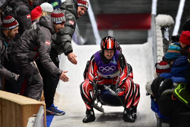 Austria's Thomas Steu with Wolfgang Kindl celebrate winning the silver medal in the finish area of the luge men's doubles run 2 at Cortina Sliding Centre during the Milano Cortina 2026 Winter Olympic Games in Cortina d'Ampezzo on February 11, 2026. (Photo by Stefano RELLANDINI / AFP)