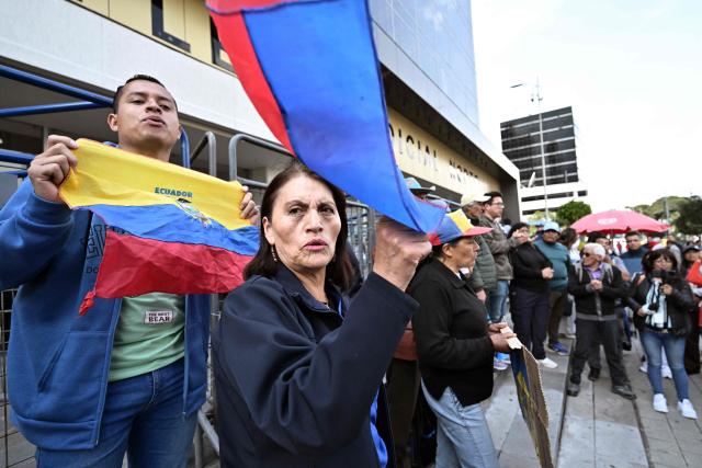 Supporters of Guayaquil mayor Aquiles Alvarez chant slogans calling for his release outside the North Judicial Complex in Quito on February 11, 2026. The mayor of Guayaquil, Aquiles Alvarez, and his brothers Xavier and Antonio, were detained on February 10, for alleged money laundering, in an operation that led to the arrest of seven other people, the Prosecutor's Office reported. Antonio Alvarez is the president of Barcelona, Ecuador's most popular football team. (Photo by Rodrigo BUENDIA / AFP)