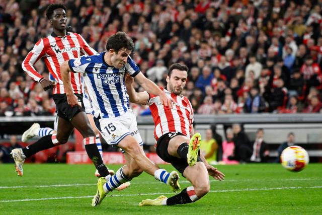 Real Sociedad's Spanish midfielder #15 Pablo Marin is tackled by Athletic Bilbao's Spanish defender #15 Inigo Lekue (R) during the Spanish Copa del Rey (King's Cup) semi final first leg football match between Athletic Club Bilbao and Real Sociedad at San Mames Stadium in Bilbao on February 11, 2026. (Photo by ANDER GILLENEA / AFP)