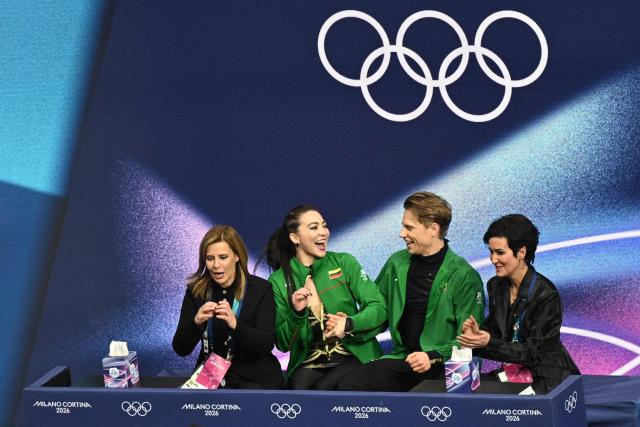 Lithuania's Allison Reed (2nd L) and Lithuania's Saulius Ambrulevicius (2nd R) react in the kiss and cry area after competing in the figure skating ice dance-free dance final during the Milano Cortina 2026 Winter Olympic Games at Milano Ice Skating Arena in Milan on February 11, 2026. (Photo by Antonin THUILLIER / AFP)