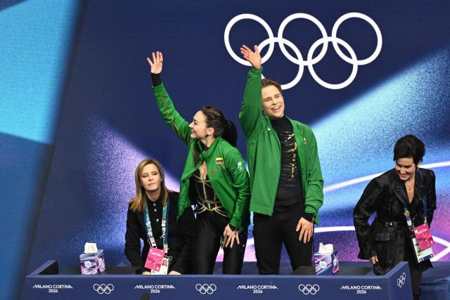 Lithuania's Allison Reed (2nd L) and Lithuania's Saulius Ambrulevicius (2nd R) react in the kiss and cry area after competing in the figure skating ice dance-free dance final during the Milano Cortina 2026 Winter Olympic Games at Milano Ice Skating Arena in Milan on February 11, 2026. (Photo by Antonin THUILLIER / AFP)