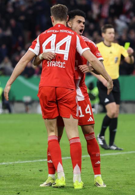Bayern Munich's Colombian forward #14 Luis Diaz celebrates scoring the 2-0 goal with his teammate Bayern Munich's Croatian defender #44 Josip Stanisic during the German Cup (DFB-Pokal) quarter-final football match between FC Bayern Munich and RB Leipzig in Munich, southern Germany on February 11, 2026. (Photo by Alexandra BEIER / AFP) / DFB REGULATIONS PROHIBIT ANY USE OF PHOTOGRAPHS AS IMAGE SEQUENCES AND QUASI-VIDEO.