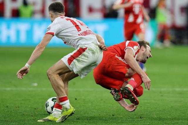 Bayern Munich's English forward #09 Harry Kane is fouled by Leipzig's Austrian midfielder #14 Christoph Baumgartner during the German Cup (DFB-Pokal) quarter-final football match between FC Bayern Munich and RB Leipzig in Munich, southern Germany on February 11, 2026. (Photo by Alexandra BEIER / AFP) / DFB REGULATIONS PROHIBIT ANY USE OF PHOTOGRAPHS AS IMAGE SEQUENCES AND QUASI-VIDEO.