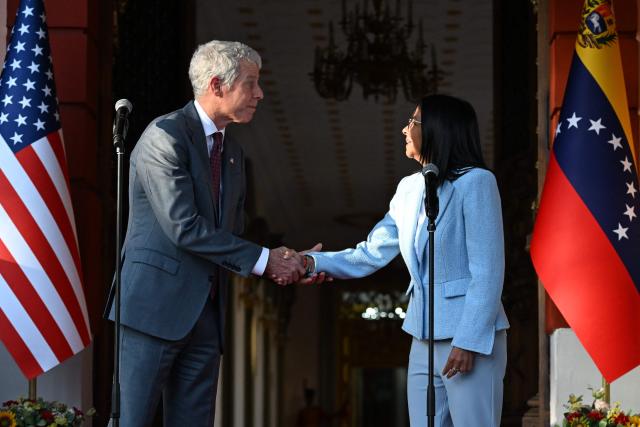 US Secretary of Energy Chris Wright (L) shakes hands with Venezuela's acting president Delcy Rodriguez during a press conference after a meeting at the Miraflores Presidential Palace in Caracas on February 11, 2026. US Energy Secretary Chris Wright arrived in Venezuela on February 11 for talks with acting president Delcy Rodriguez and oil industry executives on harnessing the country's vast crude reserves. (Photo by Juan BARRETO / AFP)