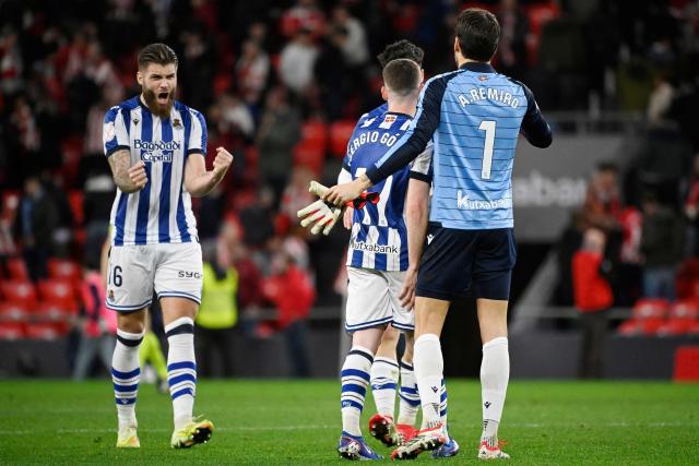 Real Sociedad's Croatian defender #16 Duje Caleta Car and Real Sociedad's Spanish goalkeeper #01 Alex Remiro celebrate at the end of the Spanish Copa del Rey (King's Cup) semi final first leg football match between Athletic Club Bilbao and Real Sociedad at San Mames Stadium in Bilbao on February 11, 2026. (Photo by ANDER GILLENEA / AFP)