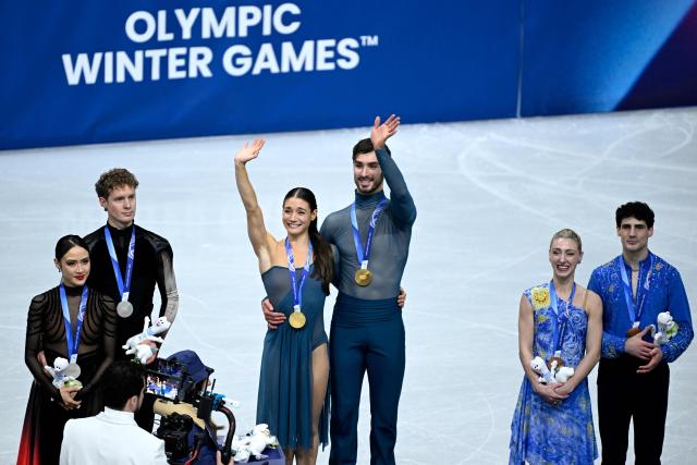 (L-R) Silver medallists USA's Madison Chock and Evan Bates, gold medallists France's Laurence Fournier Beaudry and Guillaume Cizeron and bronze medallists Canada's Piper Gilles and Paul Poirier pose on the podium of the figure skating ice dance-free dance final during the Milano Cortina 2026 Winter Olympic Games at Milano Ice Skating Arena in Milan on February 11, 2026. (Photo by WANG Zhao / AFP)