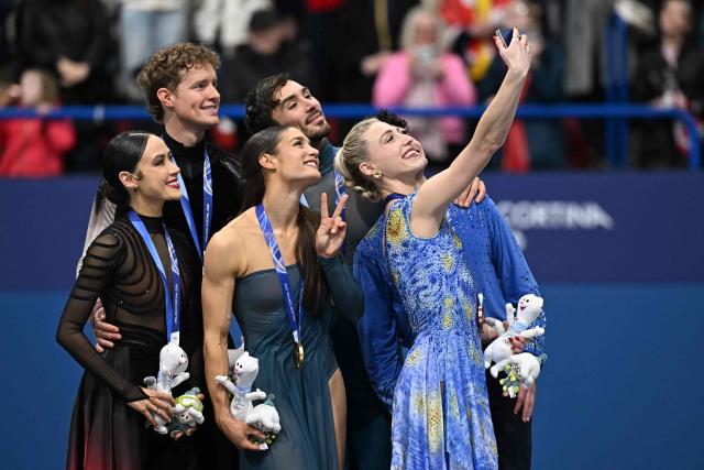 (From L) Silver medallists USA's Madison Chock and Evan Bates, gold medallists France's Laurence Fournier Beaudry and Guillaume Cizeron and bronze medallists Canada's Piper Gilles and Paul Poirier take their selfie on the podium of the figure skating ice dance-free dance final during the Milano Cortina 2026 Winter Olympic Games at Milano Ice Skating Arena in Milan on February 11, 2026. (Photo by Gabriel BOUYS / AFP)