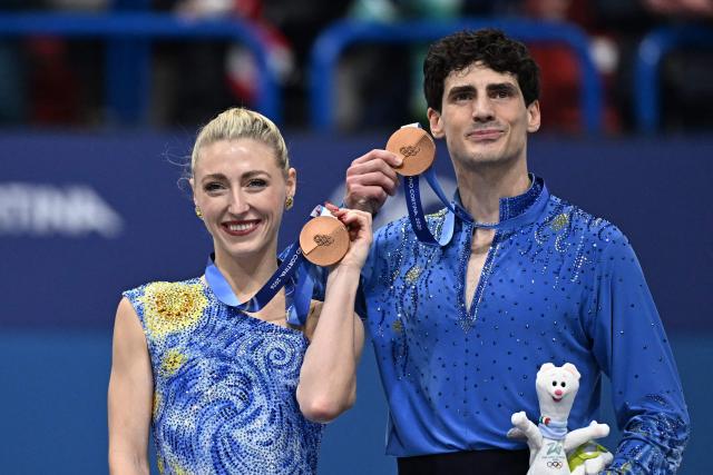 Bronze medallists Canada's Paul Poirier and Canada's Piper Gilles pose on the podium after the figure skating ice dance-free dance final during the Milano Cortina 2026 Winter Olympic Games at Milano Ice Skating Arena in Milan on February 11, 2026. (Photo by Gabriel BOUYS / AFP)