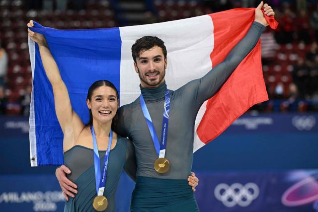 Gold medallists France's Laurence Fournier Beaudry and Guillaume Cizeron pose with the French flag on the podium of the figure skating ice dance-free dance final during the Milano Cortina 2026 Winter Olympic Games at Milano Ice Skating Arena in Milan on February 11, 2026. (Photo by Gabriel BOUYS / AFP)