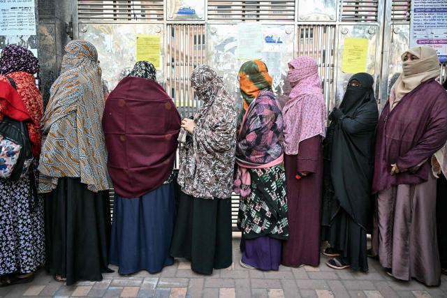 Voters line up outside polling station before polls open for Bangladesh's general election in Dhaka on February 12, 2026. (Photo by MOHD RASFAN / AFP)