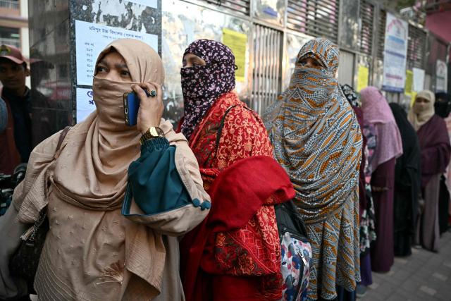 Voters line up outside a polling station before polls open for Bangladesh's general election in Dhaka on February 12, 2026. (Photo by MOHD RASFAN / AFP)