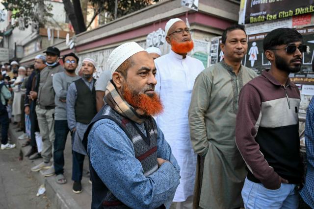 Voters line up outside a polling station before polls open for Bangladesh's general election in Dhaka on February 12, 2026. (Photo by MOHD RASFAN / AFP)
