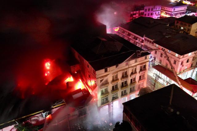 This aerial view shows firefighters working to extinguish a fire in an apartment tower in the central area of the bay of Guayaquil, Ecuador, on February 11, 2026. (Photo by Marcos PIN / AFP)