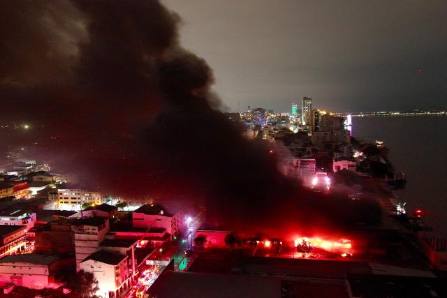 This aerial view shows the smoke over a fire in an apartment tower in the central area of the bay of Guayaquil, Ecuador, on February 11, 2026. (Photo by Marcos PIN / AFP)