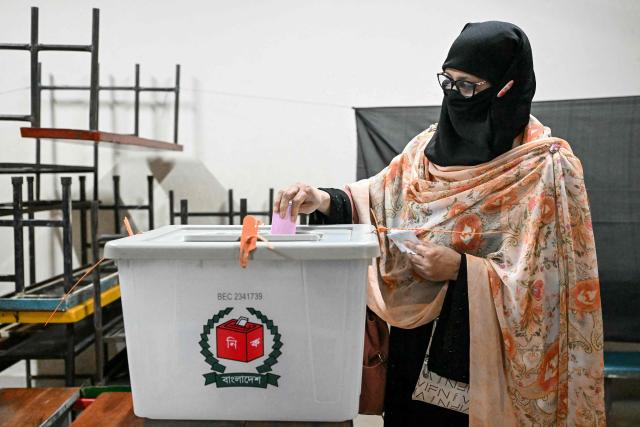 A voter casts her vote at a polling station during Bangladesh's general election in Dhaka on February 12, 2026. (Photo by MOHD RASFAN / AFP)