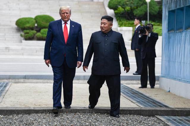 (FILES) North Korea's leader Kim Jong Un and US President Donald Trump cross south of the Military Demarcation Line that divides North and South Korea, after Trump briefly stepped over to the northern side, in the Joint Security Area (JSA) of Panmunjom in the Demilitarized zone (DMZ) on June 30, 2019. A new push to lift aid sanctions on North Korea could kickstart efforts to lure Kim Jong Un into nuclear negotiations with US President Donald Trump, analysts told AFP. (Photo by Brendan Smialowski / AFP)