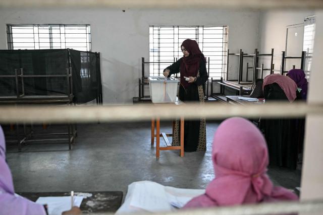 A voter casts her vote at a polling station during Bangladesh's general election in Dhaka on February 12, 2026. (Photo by Sajjad HUSSAIN / AFP)