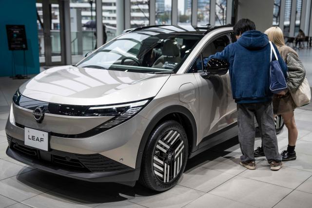 People look at a car on display at a showroom of Japanese automaker Nissan Motor in Yokohama, Kanagawa prefecture on February 11, 2026. (Photo by Yuichi YAMAZAKI / AFP)