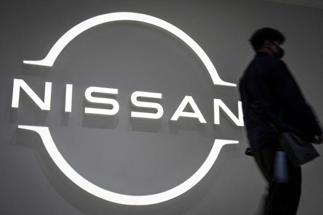 A man walks past a signage of Japanese automaker Nissan Motor at the company's showroom in Yokohama, Kanagawa prefecture on February 11, 2026. (Photo by Yuichi YAMAZAKI / AFP)