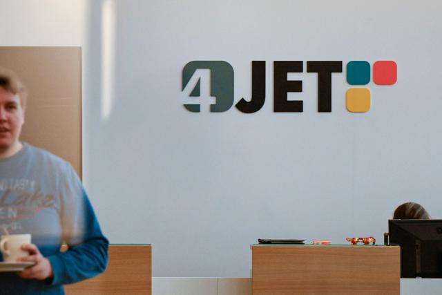 The logo of 4JET is seen in the back of a reception at the 4JET headquarters in Alsdorf, western Germany, on February 10, 2026. Insatiable demand in China for German exports, from cars to factory equipment, helped underpin a long boom in the eurozone's biggest economy. But times have changed: Chinese companies have become adept at making products long the specialities of manufacturers in Germany, adding to the headwinds that have left the country trapped in a seemingly endless decline. (Photo by Ina FASSBENDER / AFP)