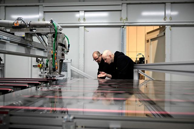 Employees work at a laser patterning machine for window glass at the headquarters of 4JET, a German firm that makes industrial laser processing technology, in Alsdorf, western Germany, on February 10, 2026. Insatiable demand in China for German exports, from cars to factory equipment, helped underpin a long boom in the eurozone's biggest economy. But times have changed: Chinese companies have become adept at making products long the specialities of manufacturers in Germany, adding to the headwinds that have left the country trapped in a seemingly endless decline. (Photo by Ina FASSBENDER / AFP)