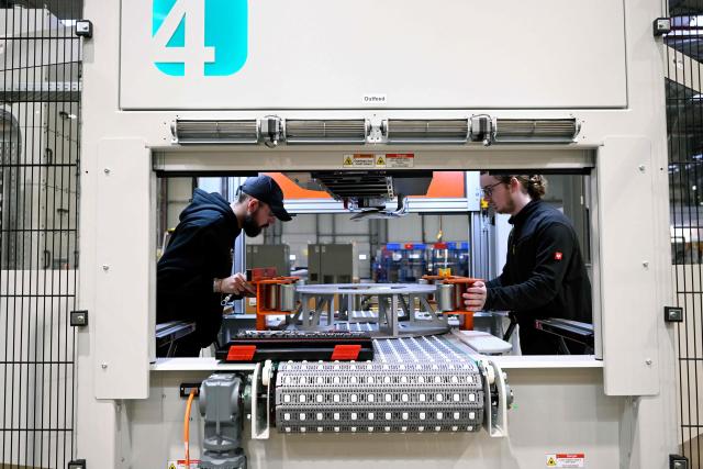 Employees work at a tyre flipper machine for the tyre marking systeme at the headquarters of 4JET, a German firm that makes industrial laser processing technology, in Alsdorf, western Germany, on February 10, 2026. Insatiable demand in China for German exports, from cars to factory equipment, helped underpin a long boom in the eurozone's biggest economy. But times have changed: Chinese companies have become adept at making products long the specialities of manufacturers in Germany, adding to the headwinds that have left the country trapped in a seemingly endless decline. (Photo by Ina FASSBENDER / AFP)