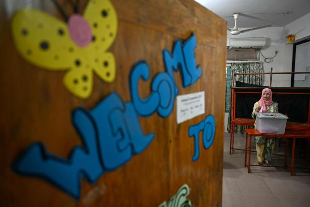 TOPSHOT - A voter casts her ballot at a polling station during Bangladesh's general election in Dhaka on February 12, 2026. (Photo by Sajjad HUSSAIN / AFP)