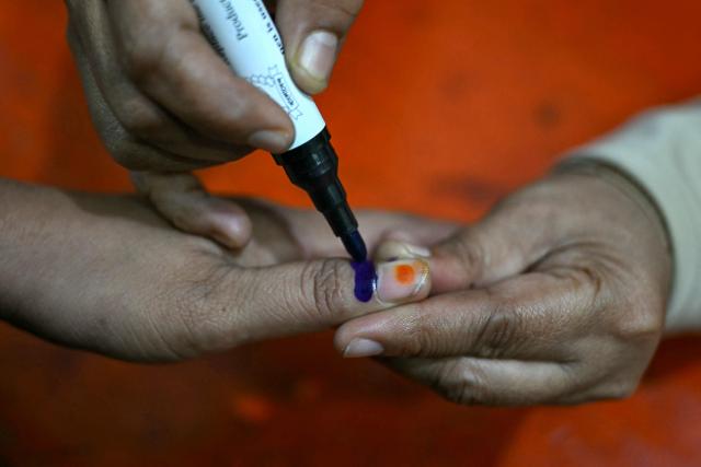 A voter has their finger marked with ink after casting their ballot at a polling station during Bangladesh's general election in Dhaka on February 12, 2026. (Photo by Sajjad HUSSAIN / AFP)