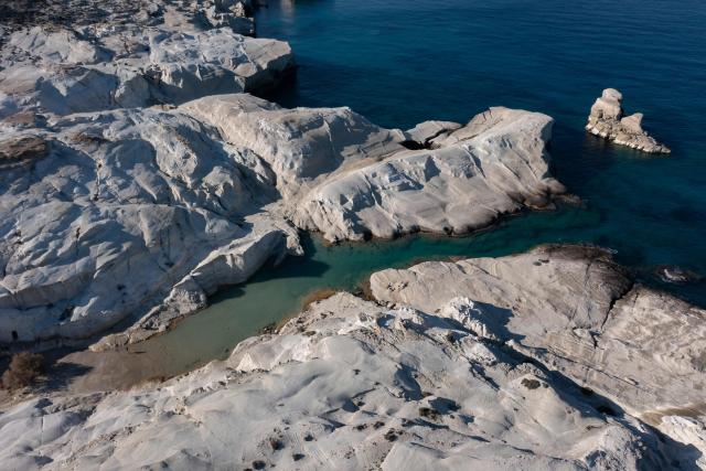 This aerial picture taken on February 3, 2026, shows Sarakiniko Beach in the Greek Aegean island of Milos. On the sloping coastline facing the Aegean Sea, the vast construction site looks like a gaping wound inflicted on the volcanic rock. ‘An ecological crime’ according to Manolis Mikelis, mayor of Milos, the Greek island in the Cyclades where this luxury hotel has begun extensive expansion work. "The geological uniqueness of Milos is known throughout the world. We don't want its identity to change," grumbles the mayor. Private villas and high-end complexes: the entire archipelago, known for its whitewashed houses and blue church domes, is caught up in a real estate fever fuelled by the tourism boom. (Photo by Aris MESSINIS / AFP)