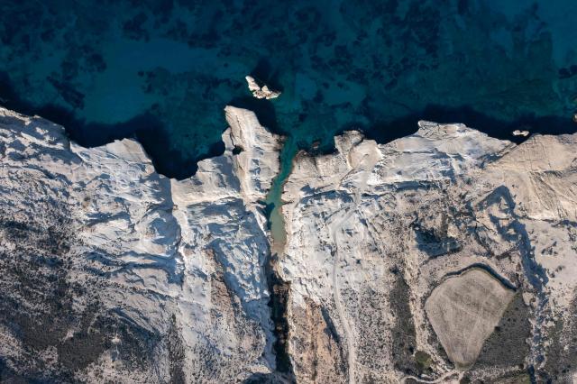 This aerial picture taken on February 3, 2026, shows Sarakiniko Beach in the Greek Aegean island of Milos. On the sloping coastline facing the Aegean Sea, the vast construction site looks like a gaping wound inflicted on the volcanic rock. ‘An ecological crime’ according to Manolis Mikelis, mayor of Milos, the Greek island in the Cyclades where this luxury hotel has begun extensive expansion work. "The geological uniqueness of Milos is known throughout the world. We don't want its identity to change," grumbles the mayor. Private villas and high-end complexes: the entire archipelago, known for its whitewashed houses and blue church domes, is caught up in a real estate fever fuelled by the tourism boom. (Photo by Aris MESSINIS / AFP)