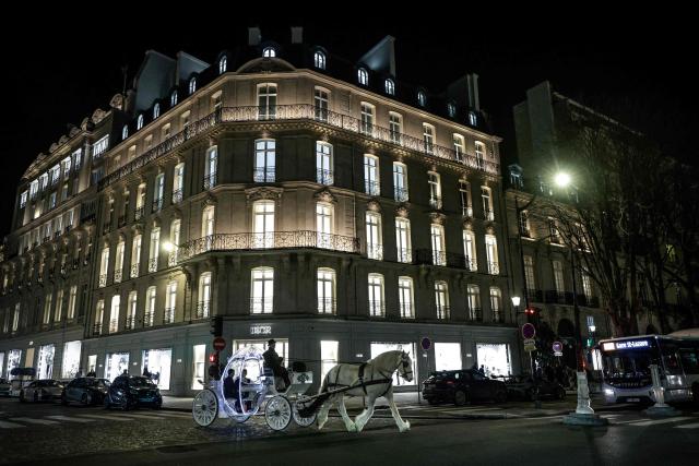 Dutch couple, Shirley Wijgaarts and Sander Castel, travel through central Paris in a fairytale horse drawn carriage during their marriage proposal, in Paris, on February 07, 2026. In Paris, marriage proposals take on a cinematic flair, complete with Cinderella's carriage, private terraces, and bespoke scenarios, creating a lucrative market fueled by international clients. (Photo by STEPHANE DE SAKUTIN / AFP)