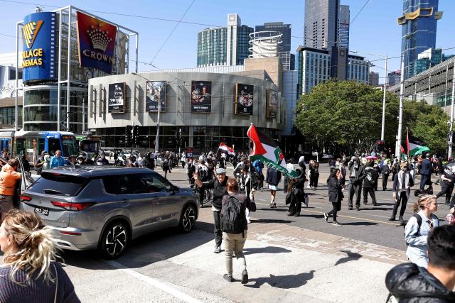 Protesters interrupt traffic as they block an intersection during the visit of Israel’s President Isaac Herzog in Melbourne on February 12, 2026. Herzog's tightly secured, four-day trip aims to console Australia's Jewish community after the December shooting at Sydney's Bondi Beach that killed 15 people at a Hanukkah festival. (Photo by MARTIN KEEP / AFP)