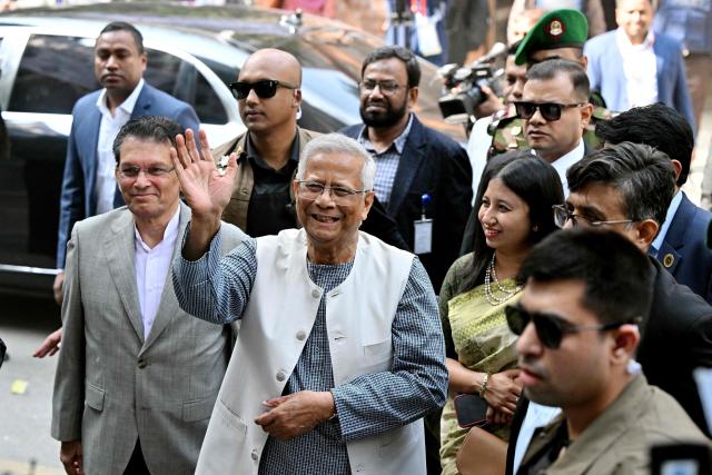 Chief Adviser of Bangladesh's Interim Government, Muhammad Yunus (C) gestures as he arrives to cast his ballot at a polling station during Bangladesh's general election in Dhaka on February 12, 2026. (Photo by MUNIR UZ ZAMAN / AFP)