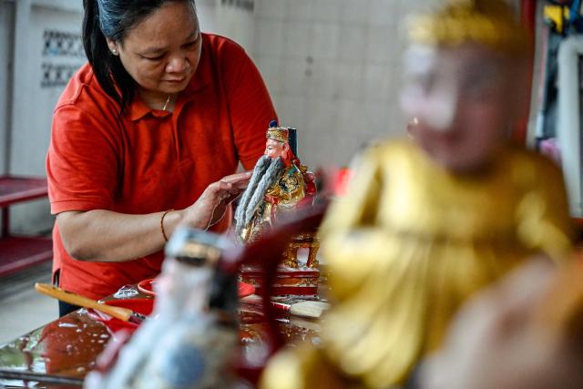 A volunteer washes a deity statue at the Dharma Bakti Temple in Banda Aceh, Indonesia's Aceh province on February 12, 2026, in preparation for the upcoming Lunar New Year of the Horse. (Photo by CHAIDEER MAHYUDDIN / AFP)